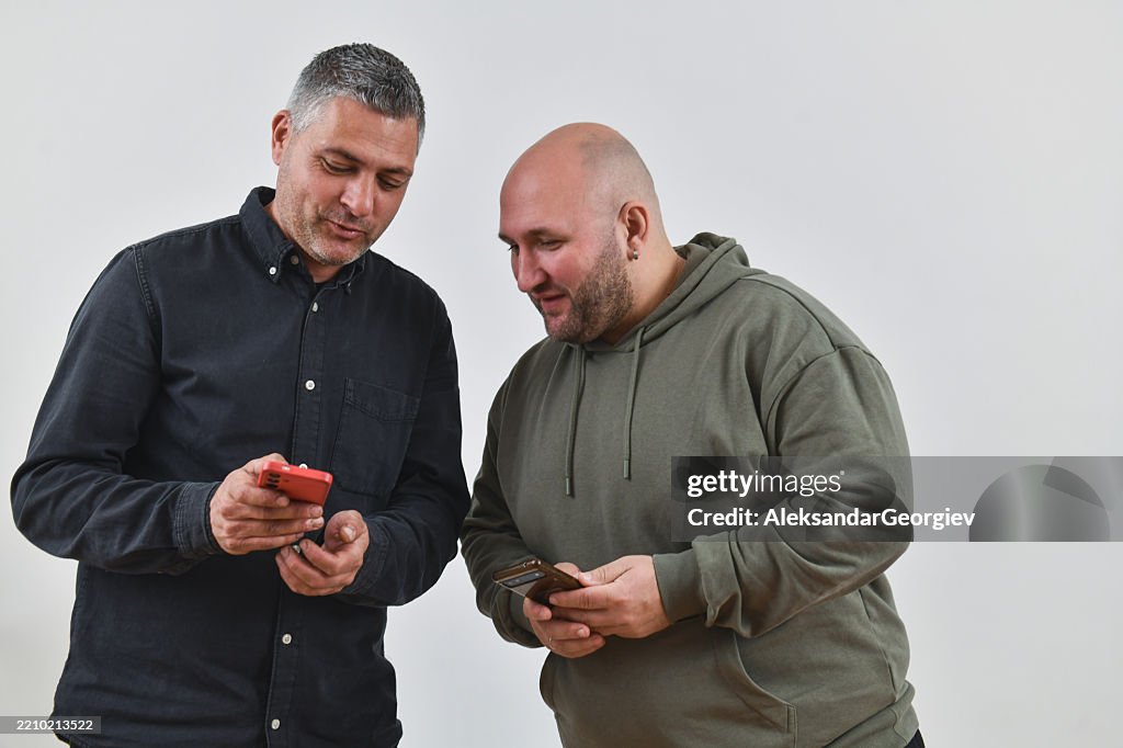 Homme montrant un mème drôle à un ami sur smartphone avec amusement