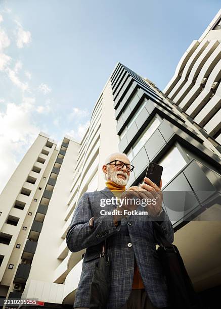 foto di un bel uomo d'affari anziano in buone condizioni che parla al telefono. - inquadratura dal basso foto e immagini stock