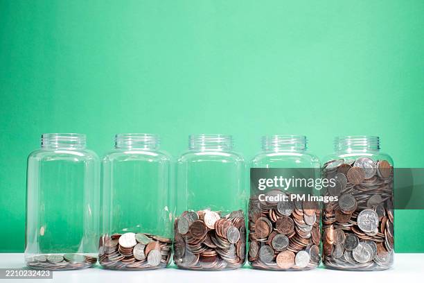 savings growth concept - 5 jars of coins ascending - counting stock pictures, royalty-free photos & images