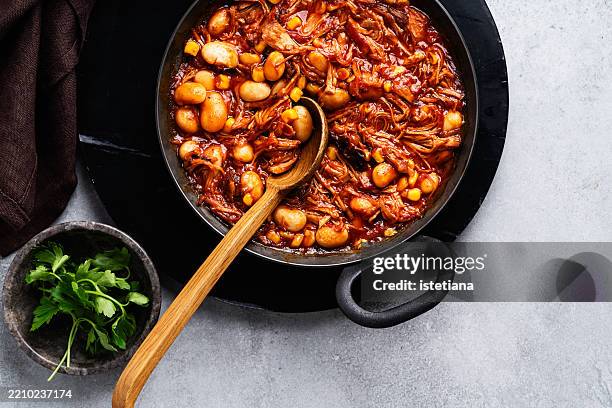 pulled pork stew with beans and corn in tomato sauce in cooking pan - bean stew stock pictures, royalty-free photos & images