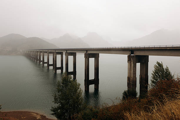 long concrete bridge crossing a reservoir under a cloudy sky - on the bridge stock pictures, royalty-free photos & images