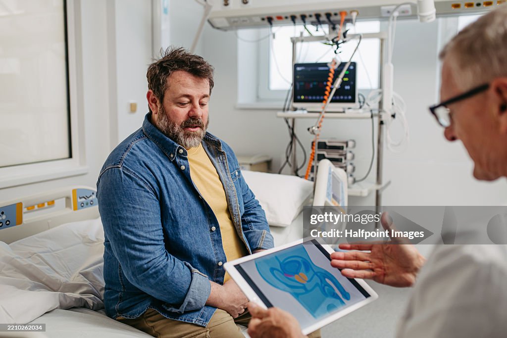 Doctor explaining prostate examination to male patient.