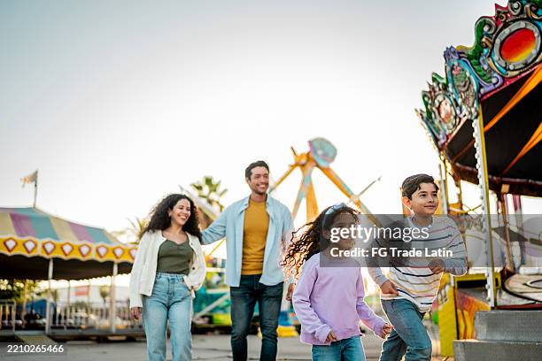 fratelli bambini che corrono sul parco divertimenti - amusement park foto e immagini stock