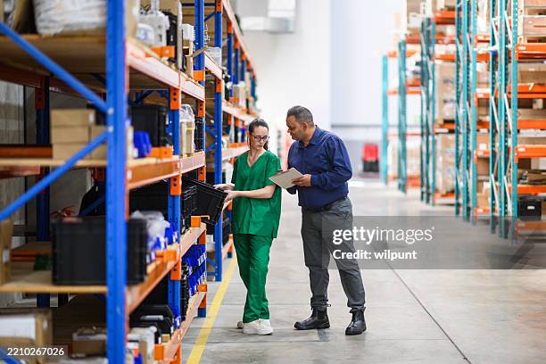 warehouse inventory check with manager and worker in medical scrubs - operating procedures standardization stock pictures, royalty-free photos & images