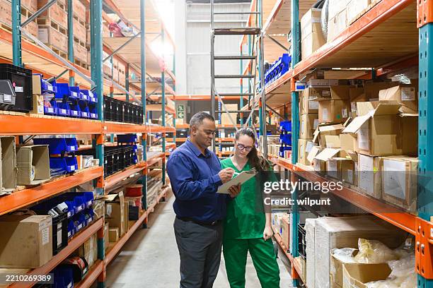 gerente y personal médico inspeccionando el inventario en un almacén de suministros para el cuidado de la salud - material médico fotografías e imágenes de stock
