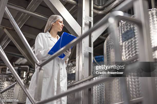 working with industry machinery at a dairy factory - hair net stock pictures, royalty-free photos & images