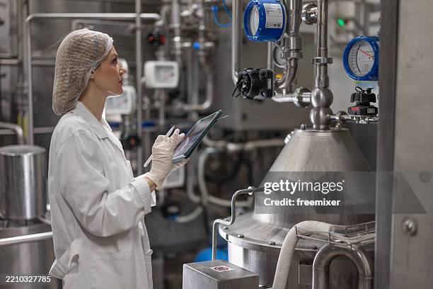 contrôle du processus de production dans une usine laitière moderne - usine agro alimentaire photos et images de collection