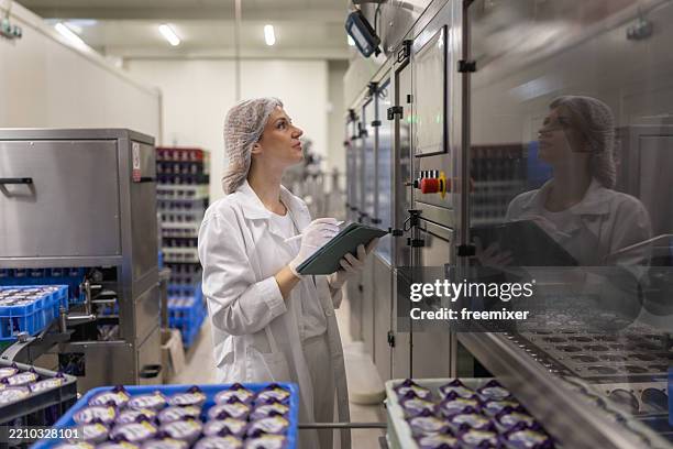 portrait of woman operating machines at food factory - voedingsindustrie stockfoto's en -beelden