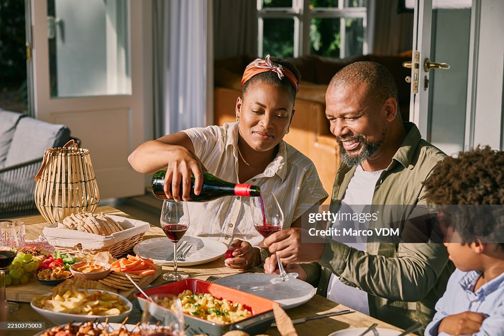 Lunch, pour and black family outdoor with wine for celebration, bonding or connection together. Food, alcohol and African people with drink for cheers with brunch in backyard of home for party.