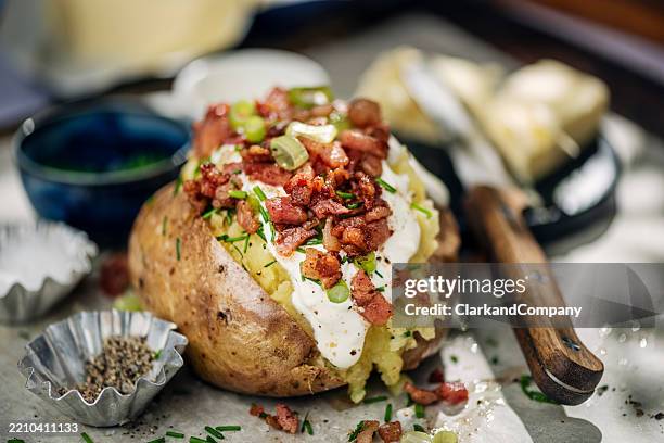 jacket potato with crispy bacon and sour cream - gepofte-aardappel stockfoto's en -beelden