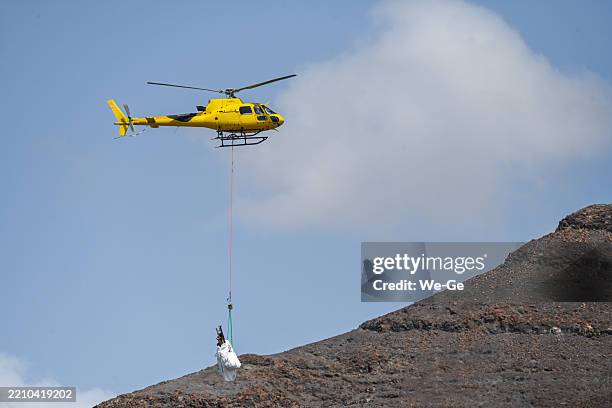 an airbus helicopters h125 of the airline sky helicopteros transporting building materials on the island of fuerteventura. - military helicopter stock pictures, royalty-free photos & images