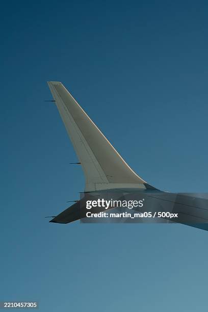 low angle view of airplane against clear blue sky,china - vliegtuigonderdeel stockfoto's en -beelden