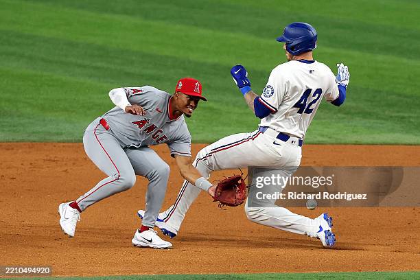 Kyren Paris of the Los Angeles Angels gets the throw as Jonah Heim of the Texas Rangers between first and second bases in the fifth inning at Globe...