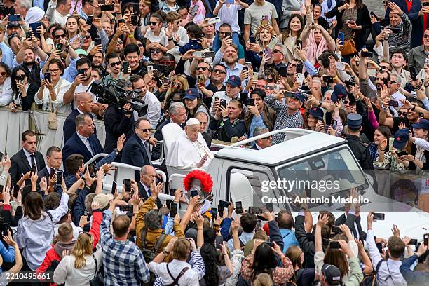 Pope Francis greets faithfuls from the popemobile during the Easter Mass as part of the Holy Week celebrations, on April 20, 2025 in Vatican City,...