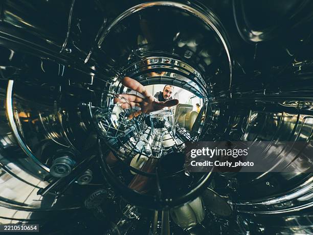 a man puts dishes in a dishwasher. view from inside the dishwasher. - vaisselle photos et images de collection