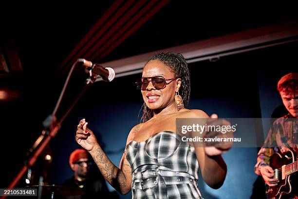 onstage portrait of black chanteuse fronting jazz band - singer stock pictures, royalty-free photos & images