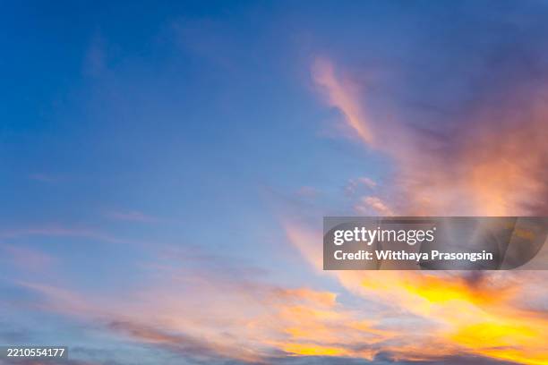 vibrant sunset sky with golden clouds during evening twilight - luce calda foto e immagini stock