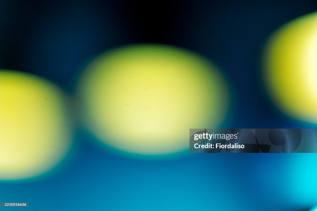 Abstract background of blurred yellow spots on blue. Element of futuristic design, light effects.
