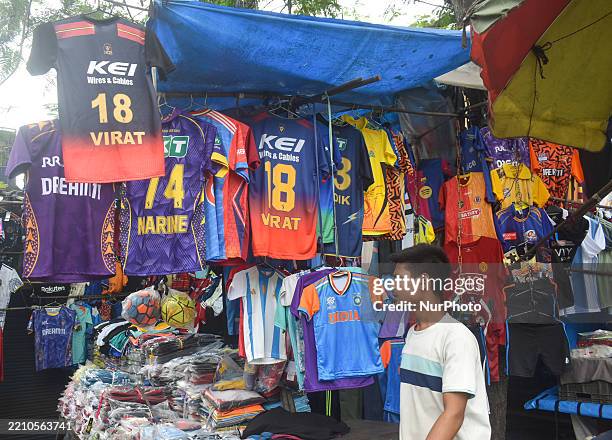 Person buys sports jerseys of IPL teams at a roadside stall in Kolkata, India, on April 20, 2025.