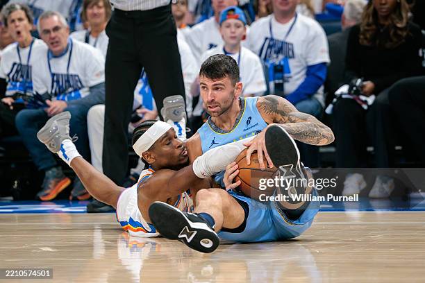 John Konchar of the Memphis Grizzlies and Shai Gilgeous-Alexander of the Oklahoma City Thunder go after a loose ball in the first quarter during Game...