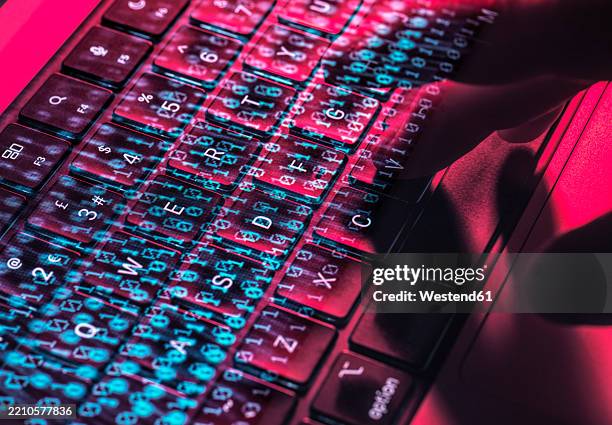 hands typing on a laptop keyboard with digital overlay representing cybersecurity and cyber crime - computer virus stockfoto's en -beelden