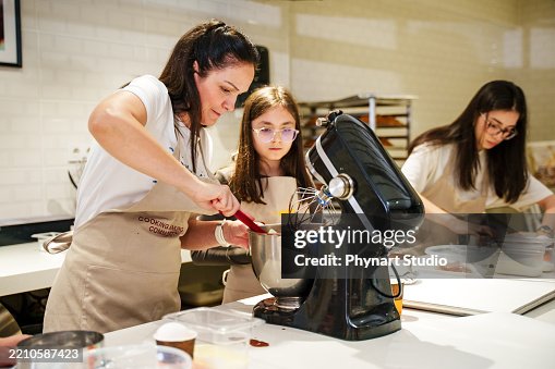 A Mum And Daughter Are Decorating Cakes In A Modern Kitchen Baking ...