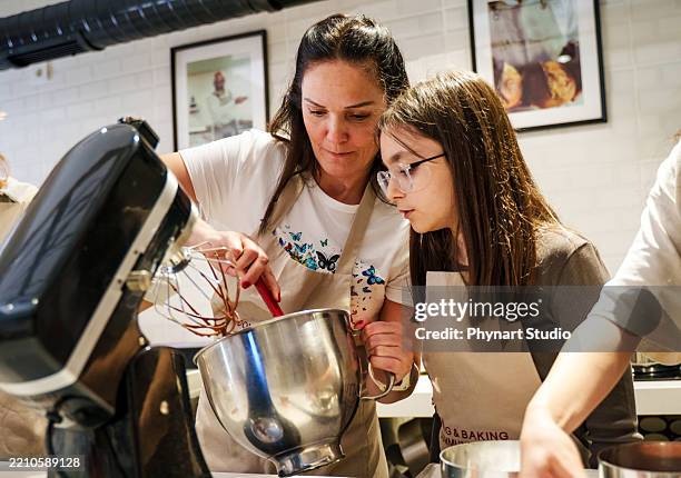 a mum and daughter are decorating cakes in a modern kitchen – baking class or workshop - gratis stockfoto's en -beelden