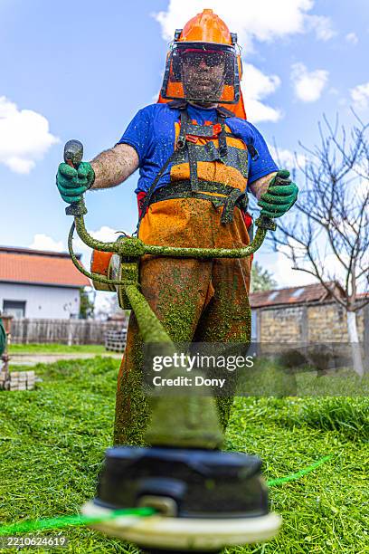 lawn maintenance, grass trimming with a string trimmer - brushcutter stock pictures, royalty-free photos & images