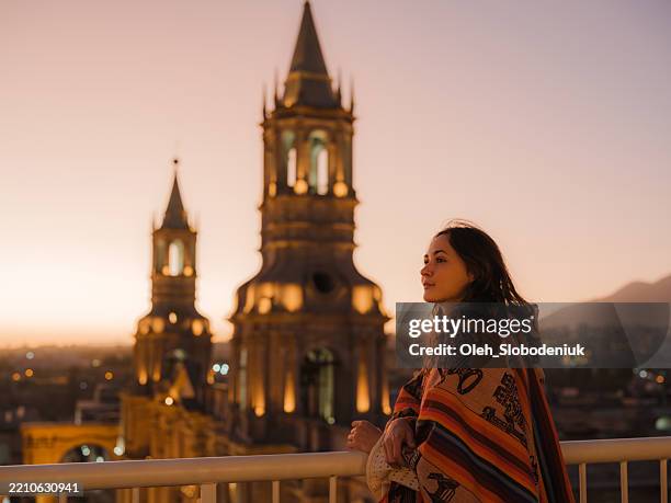 woman looking at sun setting at plaza de armas in arequipa, peru - poncho stock pictures, royalty-free photos & images