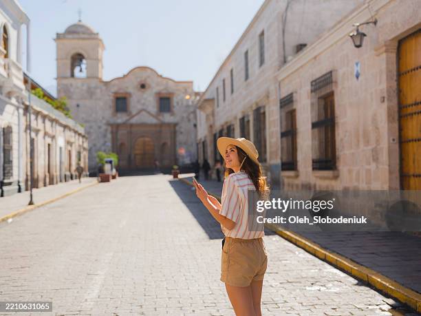 frau, die smartphone während einer reise in peru benutzt - arequipa peru stock-fotos und bilder