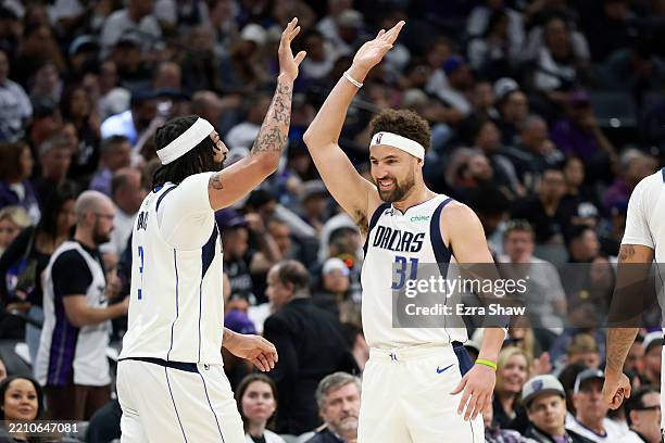 Klay Thompson high fives Anthony Davis of the Dallas Mavericks after Davis made a basket against the Sacramento Kings during the first half of the...