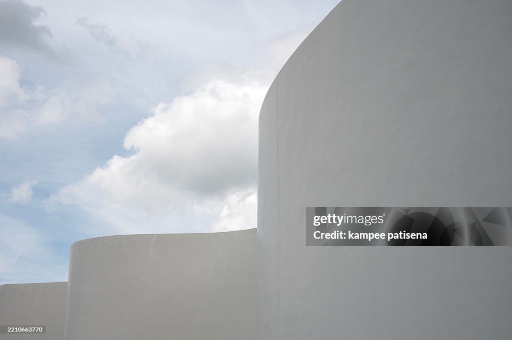 The white building against the cloudy sky.