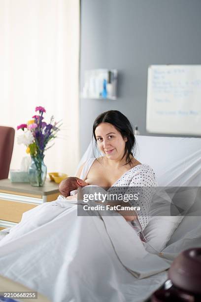 nursing newborn in the hospital - womens issues stock pictures, royalty-free photos & images