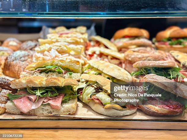 variety of stuffed sandwiches with cured meats and fresh greens - espositore per negozio foto e immagini stock