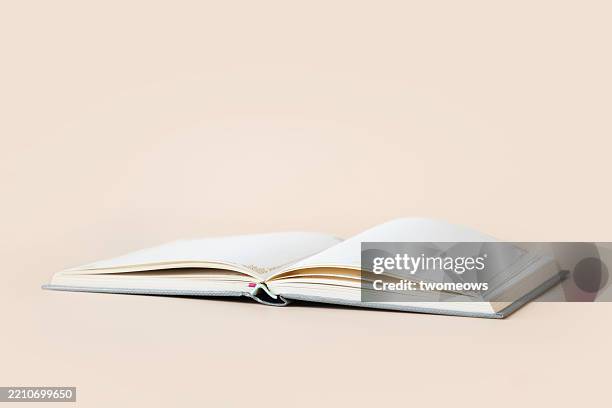 open page book on coloured background. - libro rilegato foto e immagini stock