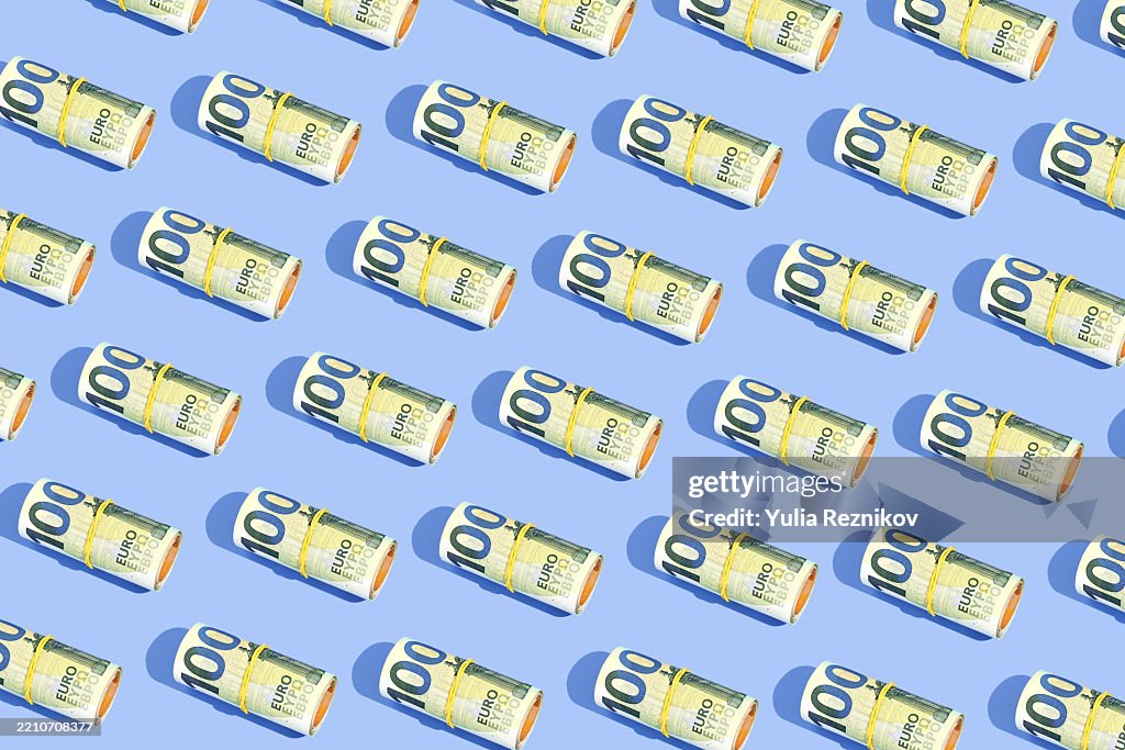 Repeated rolls 100 euro banknotes on the blue background