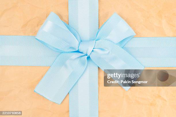 close-up light blue ribbon tied bow on old brown crumpled paper. - generic holiday card stock pictures, royalty-free photos & images