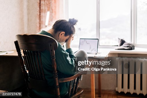 Stressed businesswoman looking at declining stock market chart on laptop Stressed businesswoman looking at declining stock market chart on laptop