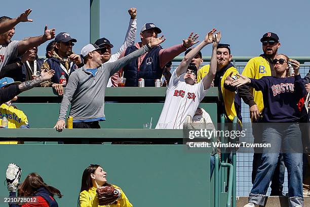 Fan in a Red Sox jersey catches a home run ball hit by Rob Refsnyder of the Boston Red Sox against the Chicago White Sox during the second inning at...