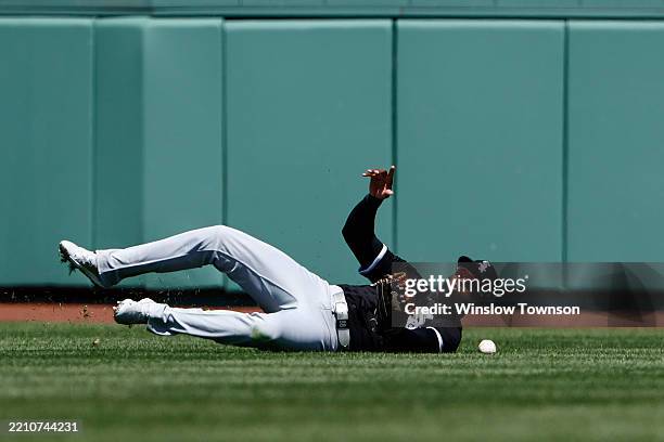Luis Robert Jr. #88 of the Chicago White Sox can't hang onto a hit by Alex Bregman of the Boston Red Sox during the seventh inning at Fenway Park on...