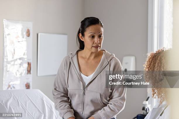 woman examined by caring medical provider - examination table stock pictures, royalty-free photos & images