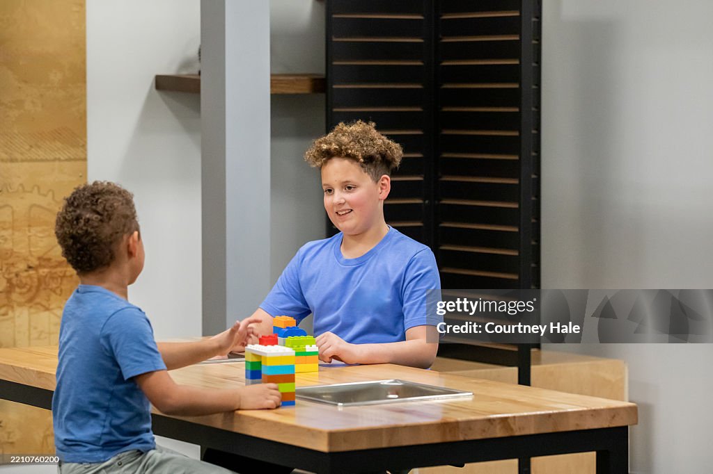 Cute little boys work on STEM project together in modern classroom