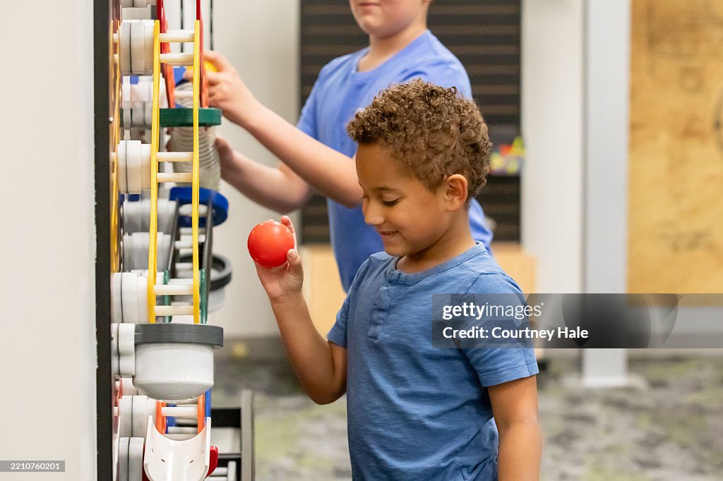 Cute little boy uses educational STEM toys in modern science classroom