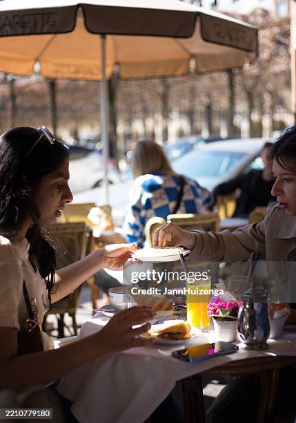 paris, france: young women at sidewalk cafe, place des vosges - le marais stock pictures, royalty-free photos & images