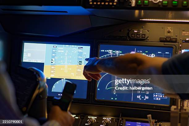 instructor enseñando a un estudiante de piloto haciendo un gesto a los paneles frontales del simulador de vuelo - simulador de vuelo fotografías e imágenes de stock