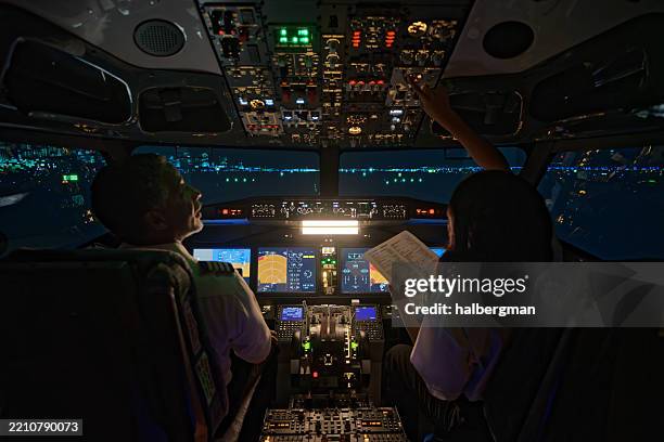 pilot and co-pilot on airport runway review flight instrumentation - night - airline cockpit stock pictures, royalty-free photos & images