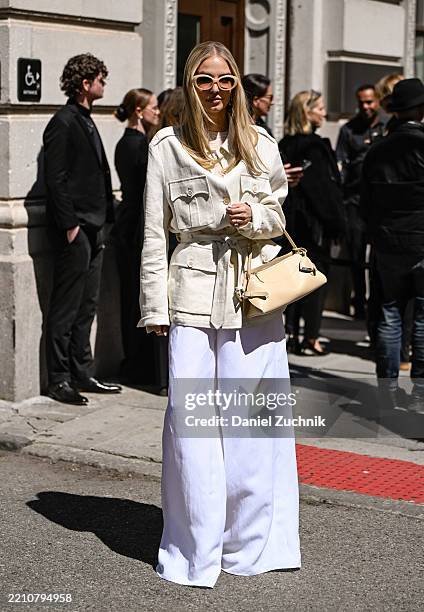 Leonie Hanne is seen wearing a Ralph Lauren belted jacket, white Ralph Lauren pants, tan bag and pink sunglasses outside the Ralph Lauren show on...