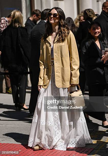 Ella Hunt is seen wearing a tan leather Ralph Lauren jacket, white Ralph Lauren dress, cream bag and brown sunglasses outside the Ralph Lauren show...