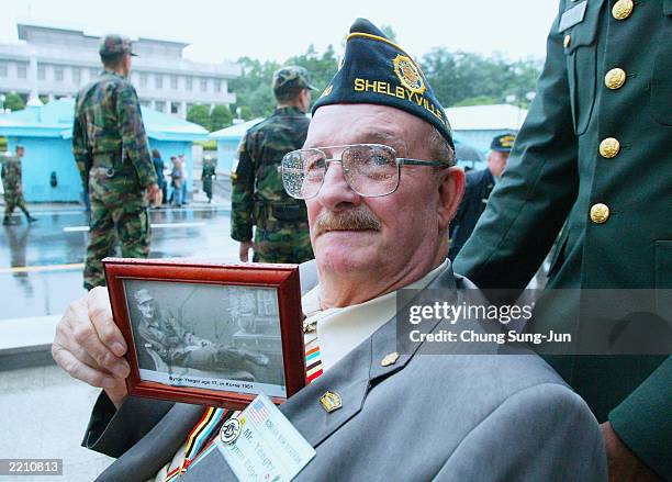 Veteran who participated in the Korean War holds a picture of himself taken during the war as he attends a ceremony July 27, 2003 in the border...