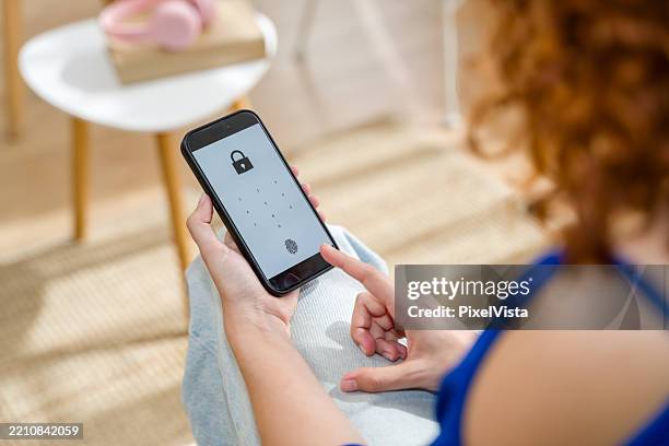 mulher que destrava o smartphone com impressão digital - destrancar - fotografias e filmes do acervo